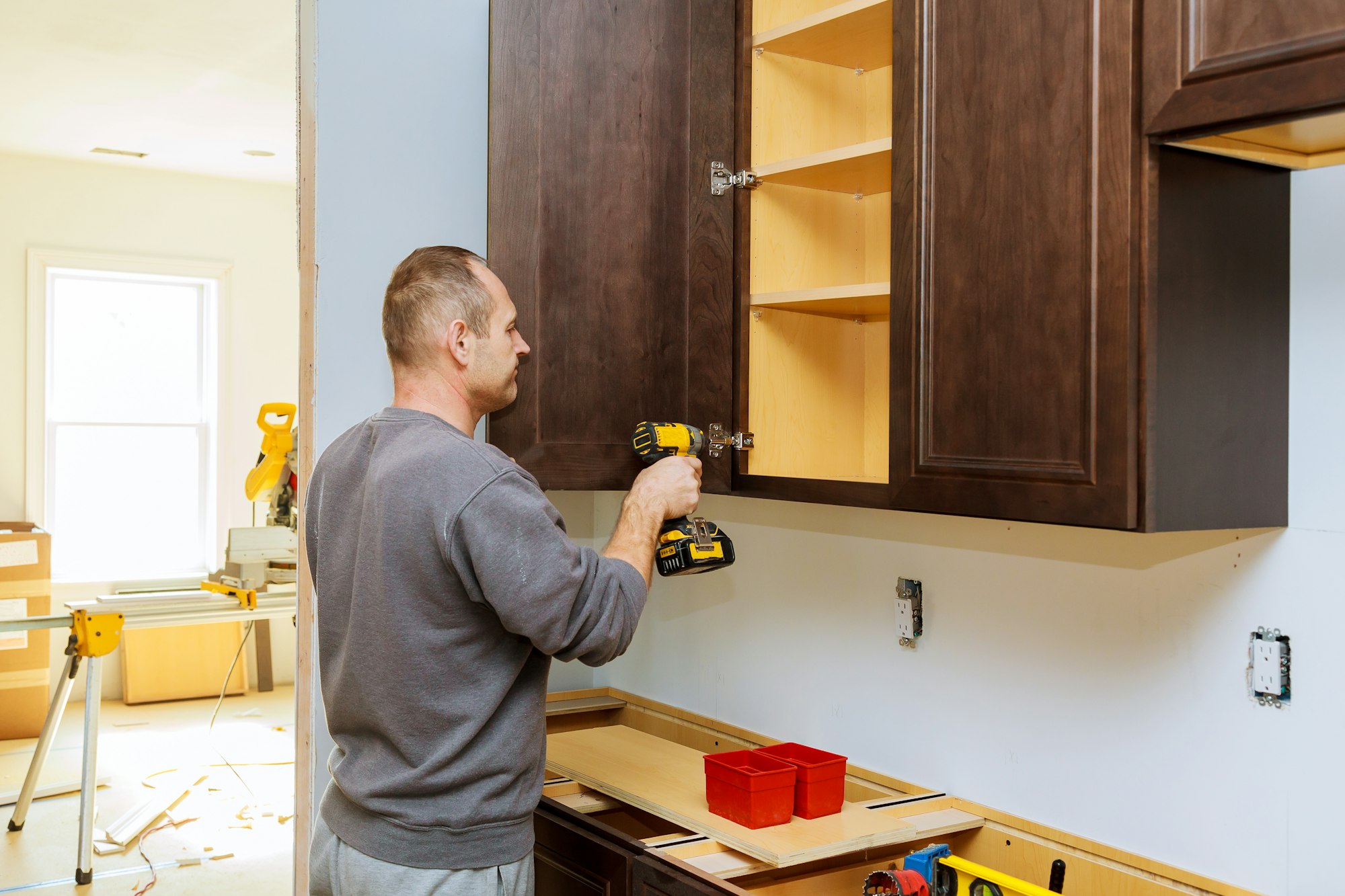 Installation of furniture hinges on the cabinet door kitchen view installed in a remodeling